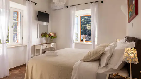 Serene double bedroom with pale linens and natural light.