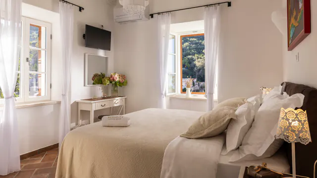 Serene double bedroom with pale linens and natural light.