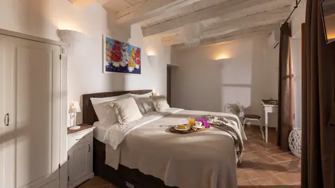 Double bedroom with exposed beams and a softly lit en-suite entrance.