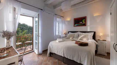 Air-conditioned double bedroom with white linens and garden light.