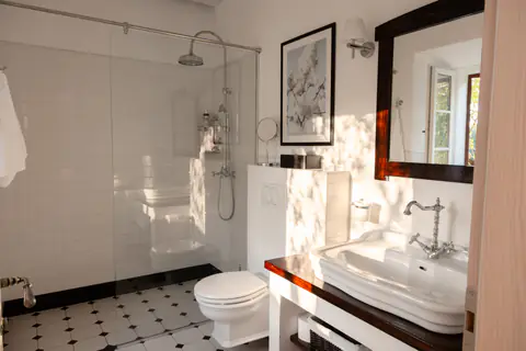 En-suite bedroom with pale stone finishes and soft natural light.