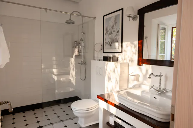En-suite bedroom with pale stone finishes and soft natural light.