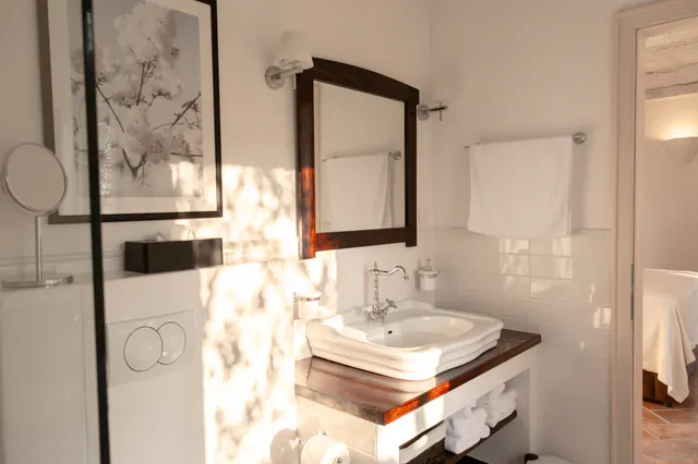 Private bedroom suite with white linens and restored architectural details.
