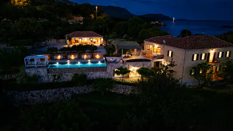 Bird's-eye evening view of the illuminated estate and terraced land.
