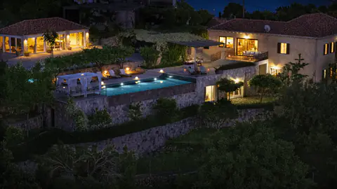 Molonta's stone houses and infinity pool illuminated after dark.