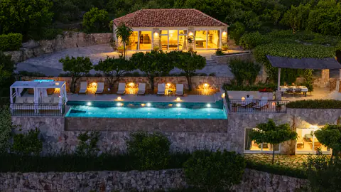 Wide view of the heritage estate set among terraced Mediterranean gardens.