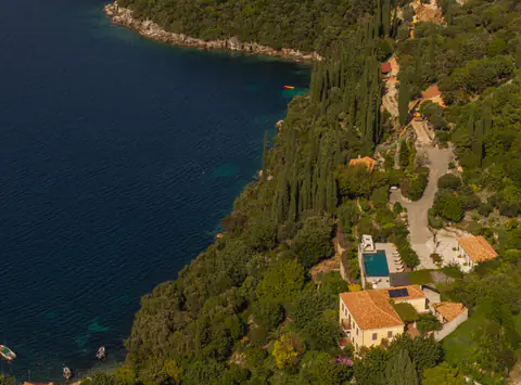 Drone view of Molonta's stone buildings, gardens, and waterfront setting.
