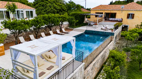 Infinity pool viewed from above with loungers arranged along the water.