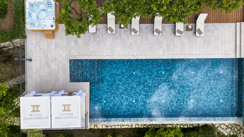 Aerial view of the infinity pool and its line of white sun loungers.