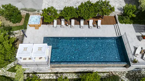 Pool and shaded cabana arranged above the Adriatic landscape.