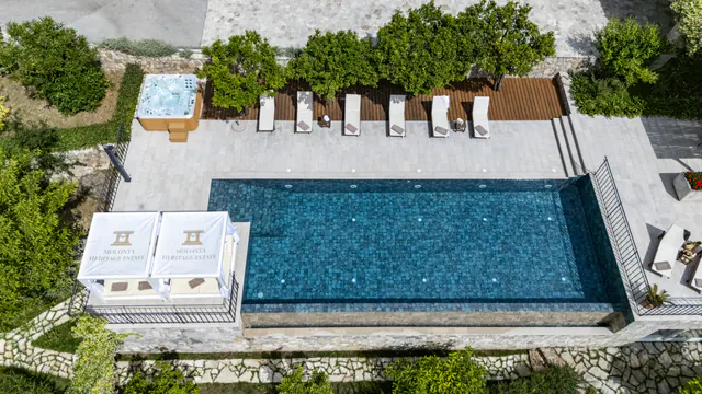 Pool and shaded cabana arranged above the Adriatic landscape.