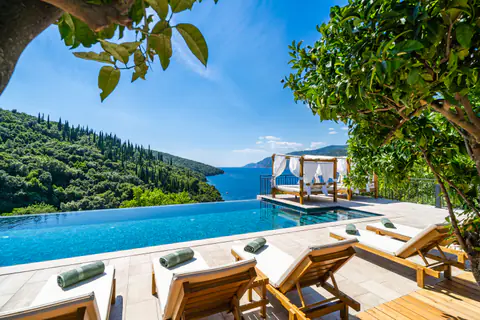 White daybed overlooking the sea from a private stone terrace.