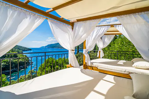Pool terrace with loungers, cabana, and hillside views.