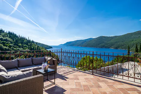 Poolside canopy and white curtains overlooking the water.