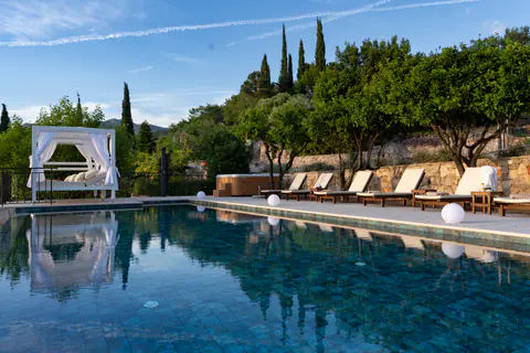 Infinity pool and white cabana glowing in the evening light.
