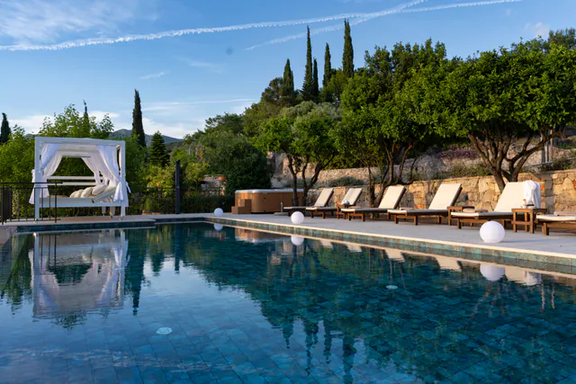 Infinity pool and white cabana glowing in the evening light.