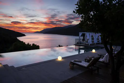Evening view across the illuminated pool and sun terrace.