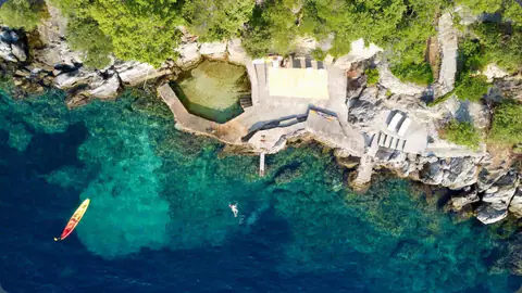 Aerial view of the stone bathing terrace on Molonta's shoreline.