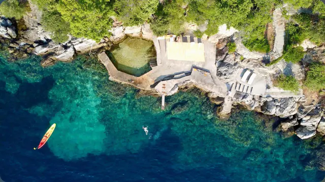 Aerial view of the stone bathing terrace on Molonta's shoreline.